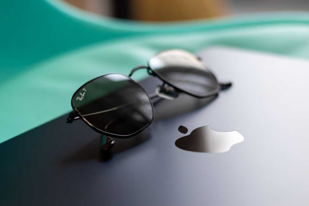 Ray Ban shades next to Apple logo on a MacBook